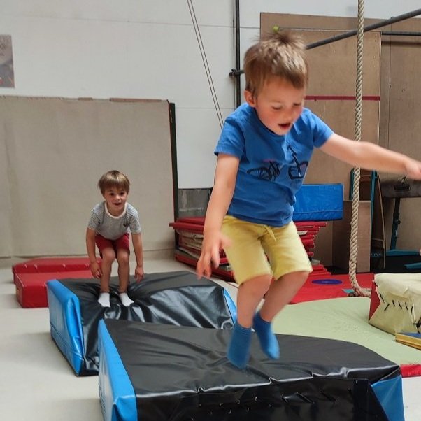 Des petits enfants sautent sur les tapis pendant un cours de motricité