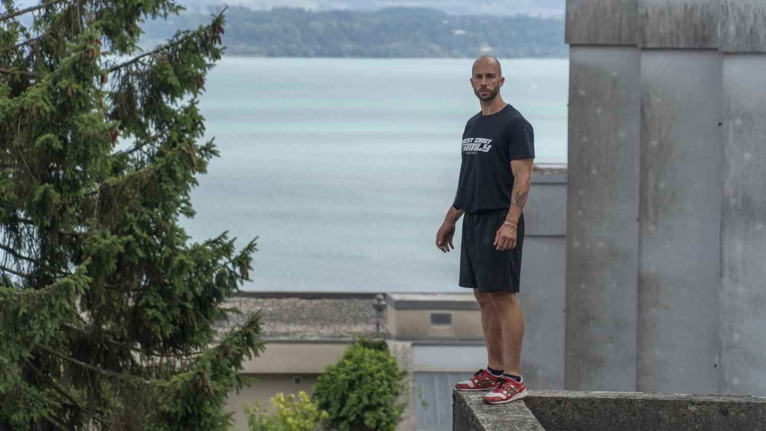 Un traceur debout sur un muret, face au lac