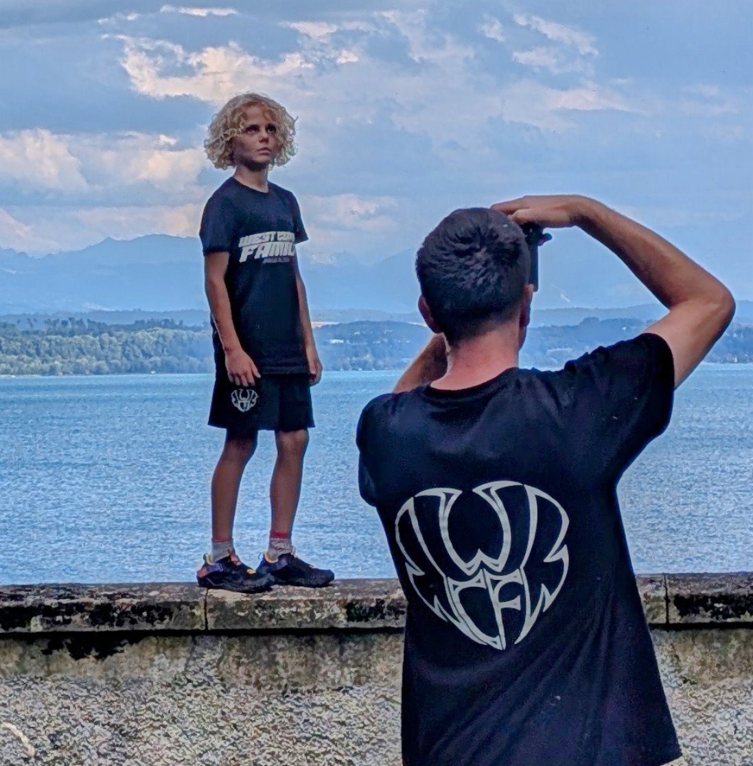 Un enfant et son coach en tee-shirt WCA, au bord du lac