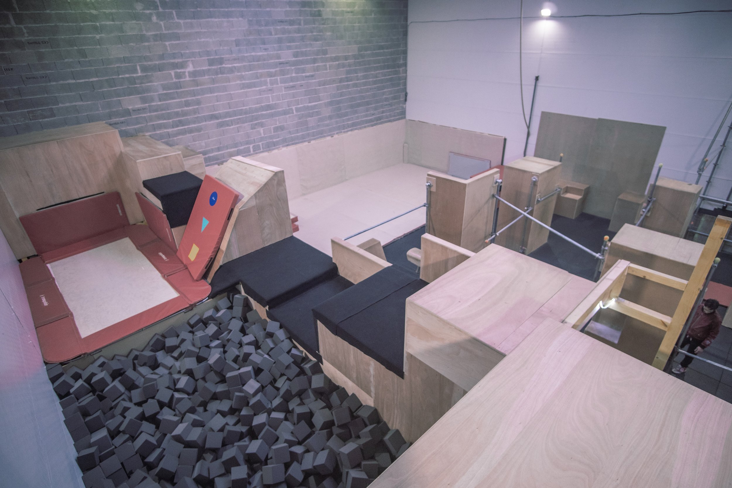 Vue large de la salle : modules en bois, barres et fosse à mousse